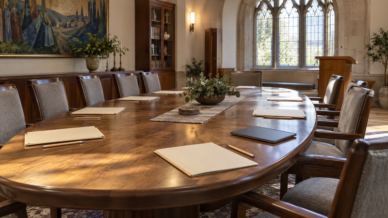 Unmarked folders and pencils are arranged around a table in an empty church meeting room.